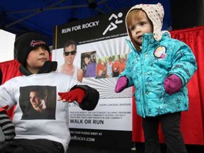 Jenna Lawson, 1, and Logan Verbeem, 10, left, both second cousins to Rocky Campana, enjoy the music before the start of the Run for Rocky at Dieppe Gardens in Windsor, Ont., Sunday, April 14, 2013.  The money raised from the Run for Rocky will help fund educational programs in partnership with gay and straight alliances in local schools.  (DAX MELMER/The Windsor Star)