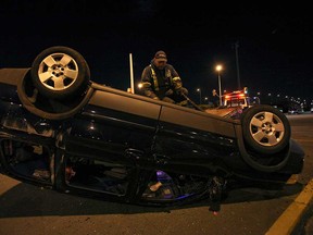 A tow truck operator tends to a rollover on the Dougall Avenue entrance ramp to E. C. Row Expressway Saturday, April 20, 2013.  (KRISTIE PEARCE / The Windsor Star)