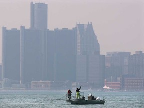 In this file photo, fishermen troll the Detroit River with the smoggy Detroit skyline in the background. (Windsor Star files)