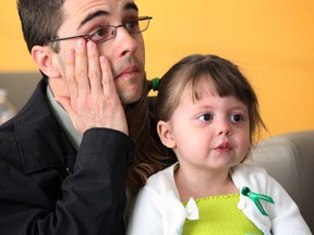 Mike Ledoux wipes a tear while viewing W-E  Can Be Heroes, a video bringing awareness to organ donation, with his daughter Emily, 2, at St. Clair College Centre for Applied Health Science in Windsor, Ont., Tuesday April 23, 2013.  Emily is on a waiting list for organ donation.   (NICK BRANCACCIO/The Windsor Star)