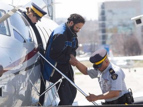 Chiheb Esseghaier, one of two men accused of plotting a terror attack on rail target, is led off a plane by RCMP officers at Buttonville Airport just north of Toronto on Tuesday. (THE CANADIAN PRESS/Chris Young)