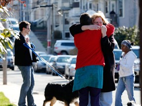 Neighbors hug outside the home of the Richard family in the Dorchester neighborhood of Boston, Tuesday, April 16, 2013. Martin Richard, 8, was killed in Monday's bombing at the finish line of the Boston Marathon. (AP Photo/Michael Dwyer)