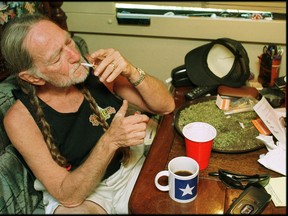 Iconic American singer/songwriter and the godfather of Outlaw Country Willie Nelson turns 80 years old on Tuesday, April 30. Nelson takes a drag off a joint while relaxing at his home in Texas, 2000s. A large amount of marijuana is spread out on the table before him (Photo by Liaison/Getty Images)