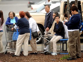 Walmart workers gather outside a Walmart in San Jose, Calif., after a motorist drove through a store entrance and began assaulting shoppers on Sunday, March 31, 2013. Four people sustained injuries during the attack according to a police spokesman. (AP Photo/Noah Berger)