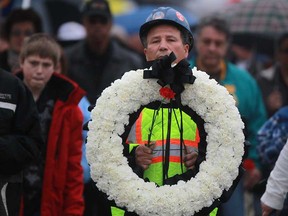 Ramiro Escoto carries a wreath as people march down Wyandotte Street East during the National Day of Mourning tribute, Sunday, April 28, 2013.  Escoto's son, Takis Escoto, died at 34 years of age after being injured on the job.  (DAX MELMER/The Windsor Star)