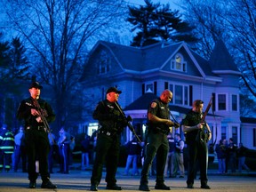 Police officers guard the entrance to Franklin street where there is an active crime scene search for suspect in the Boston Marathon bombings, Friday, April 19, 2013, in Watertown, Mass. Gunfire erupted Friday night amid the manhunt for the surviving suspect in the Boston Marathon bombing, and police in armored vehicles and tactical gear rushed into the Watertown neighborhood in a possible break in the case. (AP Photo/Matt Rourke)