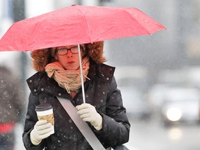 A woman uses an umbrella during a storm that brought some snow and a fast plunge in temperature overnight to downtown Denver, Tuesday April 9, 2013. The storm has so far proved less potent than originally predicted in Colorado because the cold front lingered in Wyoming. Up to around 10 inches of snow had fallen in Colorado's mountains by dawn Tuesday. Another 5 to 10 inches was possible in some locations but final snowfall amounts would vary quite a bit, National Weather Service forecaster Jim Daniels said. (AP Photo/Brennan Linsley)