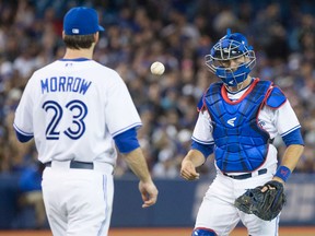 Toronto catcher J.P. Arencibia, right, tosses the ball to pitcher Brandon Morrow after a fielding error by Colby Rasmus. (THE CANADIAN PRESS/Chris Young)