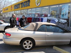 Windsor police officers examine a car that crashed into the front of the Giant Tiger store at 4501 Tecumseh Rd. East in Windsor, Ont. on Apr. 22, 2013. (Nick Brancaccio / The Windsor Star)