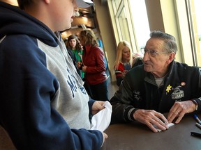 Walter Gretzky, right, signs an autograph for Nicholas Phillips at the WFCU Centre prior to the start of a NHL Alumni vs. local Law Enforcement hockey game in Windsor. (TYLER BROWNBRIDGE/The Windsor Star)