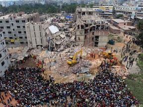 Bangladeshi volunteers and rescue workers are pictured at the scene after an eight-storey building collapsed in Savar, on the outskirts of Dhaka, on April 25, 2013. Survivors cried out to rescuers April 25 from the rubble of a block of garment factories in Bangladesh that collapsed killing 175 people, sparking criticism of their Western clients. AFP PHOTO/Munir uz ZAMAN