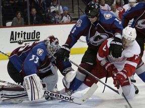 Colorado goalie Jean-Sebastien Giguere, left, lunges for the puck as Avalanche defenceman Shane O'Brien, centre, checks Detroit's Justin Abdelkader Friday in Denver. (AP Photo/Joe Mahoney)