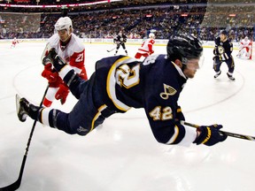 Blues captain David Backes, right, is tripped by Detroit's Tomas Tatar. (AP Photo/St. Louis Post-Dispatch, Chris Lee)