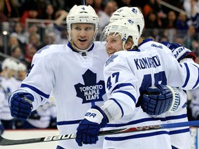 Toronto's Leo Komarov, right, celebrates his goal with Cody Franson, left, and Mark Fraser during the first period against the New Jersey Devils. (AP Photo/Bill Kostroun)