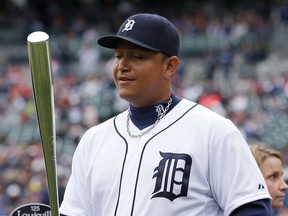 Detroit Tigers third baseman Miguel Cabrera holds the silver American League batting championship bat presented to him before the Tigers' game against the New York Yankees in Detroit Saturday. (AP Photo/Carlos Osorio)