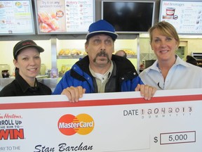 Tim Hortons manager Stacey Young, MasterCard winner Stan Barchan, and Tim Hortons owner Vicky Smith hold the 5,000 prize. (Taylor Renkema/ The Windsor Star)