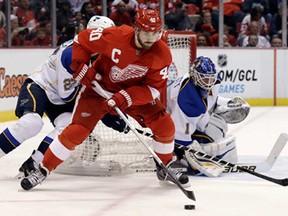 Detroit's Henrik Zetterberg, centre, carries the puck in front of St. Louis Blues goalie Brian Elliott in Detroit, Sunday, April 7, 2013. (AP Photo/Paul Sancya)