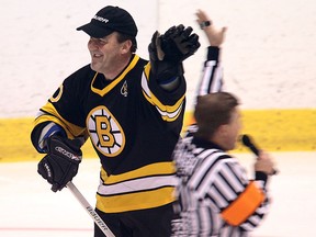 Boston Bruins alumni player Bruce Shoebottom gets a high five from referee Kerry Fraser as they take on the Law Enforcement Team during the Oldtimers Hockey Challenge at Windsor Arena on February 17, 2012. (Windsor Star files)