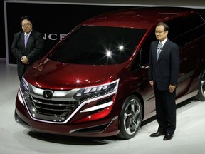 Honda Motor Co. CEO Takanobu Ito, right, and Seiji Kuraishi, president of Honda Motor (China), left, pose for photographers with the company's new Concept M at the Shanghai International Automobile Industry Exhibition  media day in Shanghai, China Saturday, April 20, 2013. (AP Photo/Eugene Hoshiko)