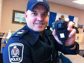 Amherstburg police Sgt. Scott Riddell shows off his body worn video camera built into his service radio mic on Friday, April 19, 2013. (Twitpic: Nick Brancaccio/The Windsor Star)