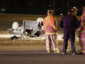 Firefighters gather by the wreck of a pickup truck that rolled over on the E.C. Row Expressway at Dougall Avenue in Windsor, Ont. on Mar. 29, 2013. Stacy Laporte, 43, the sole occupant of the truck, was killed in the accident. (Rebecca Wright / The Windsor Star)