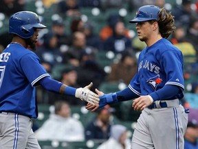 Toronto's Colby Rasmus, right, is congratulated by Jose Reyes after scoring on an Emilio Bonifacio double in the fifth inning against the Detroit Tigers in Detroit Wednesday, April 10, 2013. (AP Photo/Paul Sancya)