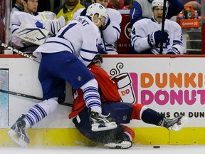 Toronto's Jay McClement, left, checks Washington's Nicklas Backstrom into the boards in the first period Tuesday, April 16, 2013 in Washington. (AP Photo/Alex Brandon)