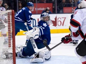 Maple Leafs goaltender James Reimer, left, makes a save on New Jersey Devils left winger Steve Sullivan during the first period in Toronto on Monday April 15, 2013. THE CANADIAN PRESS/Frank Gunn