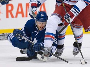 Maple Leafs defenceman Carl Gunnarsson, left, battles for the puck against New York 's forward Rick Nash in Toronto on Monday, April 8, 2013. THE CANADIAN PRESS/Nathan Denette