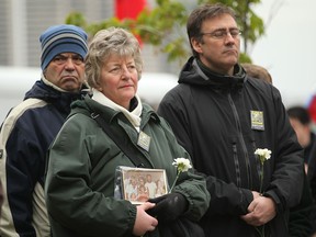 Linda Raniwsky, from Windsor, holds a photo of her late brother, Johnny Hunt with his family, while at a ceremony marking the National Day of Mourning at Dieppe Park, Saturday, April 28, 2012.  Raniwsky's brother died while on the job at a construction site in 1980,  (DAX MELMER/The Windsor Star)