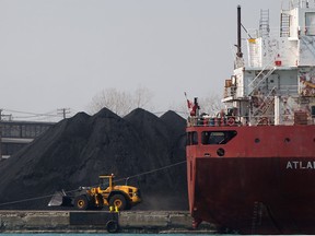 A front-end loader works to move a pile of petroleum coke at the Detroit Harbour on March 30, 2013. (Dax Melmer / The Windsor Star)
