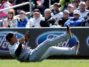 Detroit's Omar Infante tumbles after falling to field a single hit by Minnesota Twins' Justin Morneau during the first inning Thursday April 4, 2013, in Minneapolis. (AP Photo/Jim Mone)