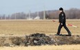 A Chatham-Kent police officer studies the ditch where a car driven by Johan Bergen Jr. crashed and burned on Feb. 5, 2012. (Dax Melmer / The Windsor Star)