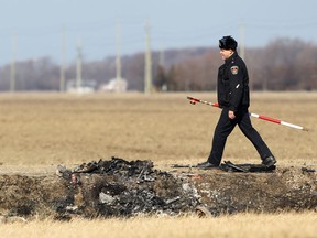 A Chatham-Kent police officer studies the ditch where a car driven by Johan Bergen Jr. crashed and burned on Feb. 5, 2012. (Dax Melmer / The Windsor Star)