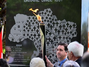 Peter Mycak, president of the Windsor Branch of the Ukranian Canadian Congress, holds the International Remembrance Flame during a ceremony raising awareness of the 75th anniversary of the Holodomor Ukranian Genocide, where as many as 10 million Ukrainians perished of starvation.  Brian Masse, centre, M.P. Windsor West and Joe Comartin, M.P. Windsor Tecumseh, and city councillor Ron Jones addressed a gathering of about 60 members of the local Ukrainian community at Jackson Park.  See story.  The Windsor Star - Nick Brancaccio