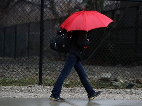 A woman carries an umbrella as she makes her way along Wyandotte Street in Windsor in this 2013 file photo. (TYLER BROWNBRIDGE/The Windsor Star)