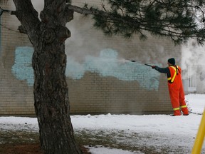 Graffiti is washed off with a high-pressure steam cleaner on a wall at a public housing unit beside the College Avenue Community Centre on the city's west side Tuesday December 21, 2010. (Windsor Star files)
