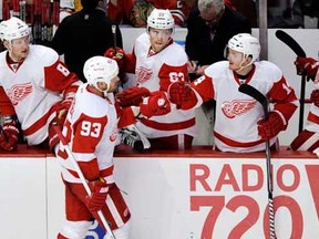 Red Wings forward Johan Franzen, front, celebrates with teammates after scoring a goal against the Chicago Blackhawks during the second period of an NHL hockey game in Chicago, Friday, April 12, 2013. (AP Photo/Paul Beaty)