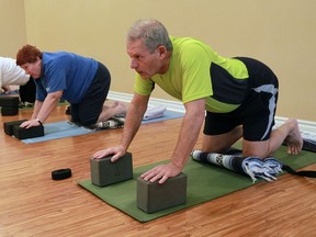Jim Rodrigues, right, takes part in a yoga for zoomers class at Blossoming Lotus Studio in LaSalle. (TYLER BROWNBRIDGE / The Windsor Star)