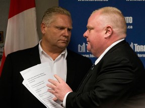 Toronto Mayor Rob Ford, right, walks past his brother Doug after reading a statement to the media in Toronto on Friday, May 24, 2013. THE CANADIAN PRESS/Chris Young