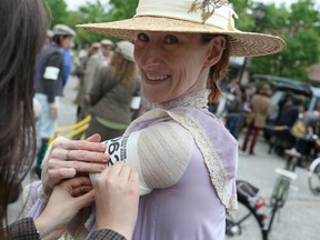 Briar Jansons, dressed in Edwardian clothing, gets help with her arm band before the start of the Spring 2013 Windsor Tweed Ride at Willistead Manor, Saturday, May 11, 2013.  (DAX MELMER/The Windsor Star)