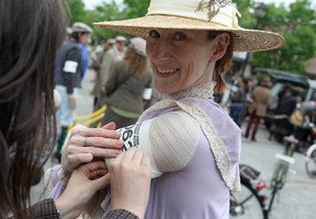 Briar Jansons, dressed in Edwardian clothing, gets help with her arm band before the start of the Spring 2013 Windsor Tweed Ride at Willistead Manor, Saturday, May 11, 2013.  (DAX MELMER/The Windsor Star)