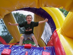 A youngster jumps for joy inside the Bouncy Castle, part of the Art in the Park Kids Zone fun that's geared to children.