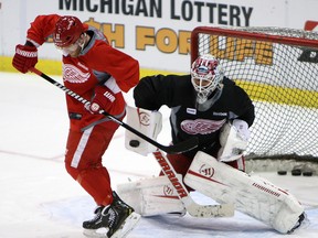 Detroit's Daniel Cleary, left, deflects a shot in front of goaltender Jonas Gustavsson during practice at Joe Louis Arena Friday. (TYLER BROWNBRIDGE/The Windsor Star)