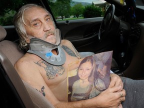John Berry poses with a photo of his daughter, Amanda Berry, outside his home in Elizabethton, Tenn., on Wednesday, May 8, 2013. Amanda Berry is one of three women who were rescued from a Cleveland home on Monday after they went missing separately about a decade ago, when they were in their teens or early 20s. (AP Photo/Patrick Murphey-Racey)