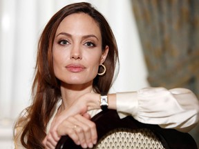 In this Saturday, Dec. 3, 2011 file photo, actress Angelina Jolie poses for a portrait to promote her directorial debut of the film "In the Land of Blood and Honey" in New York. Jolie authored an op-ed for Tuesday’s May 14, 2013 New York Times where she writes that in April she finished three months of surgical procedures to remove both breasts as a preventive measure. She says she’s kept the process private but is writing about it now with hopes she can help other women. (AP Photo/Carlo Allegri, File)