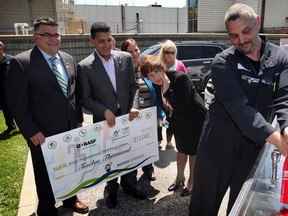 Windsor Mayor Eddie Francis, second from left, and BASF Canada Site Director Guido Broche, left, and Teresa Czerwinski, centre, watch as BASF plant worker Brian Charron fills a re-usable water bottle from a Hydration Station following a donation of $12,000 on Wednesday, May 15, 2013,  to the City's Green Games initiative for the 2013 International Children's Games to be held in Windsor Aug. 14-19.  (NICK BRANCACCIO/The Windsor Star)