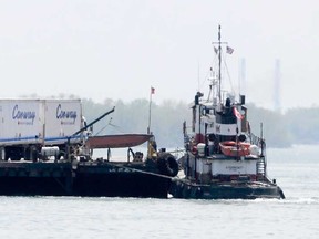 An international truck ferry carries trucks across the Detroit River to Canada on Wednesday, May 8, 2013. The Michigan Department of Transportation will keep the ban on trucking hazardous materials across the Ambassador Bridge. (AP Photo/Detroit News, Elizabeth Conley)