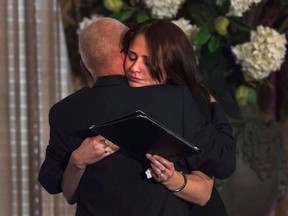 Widow Sharlene Bosma receives a hug from Tim Bosma's father at a memorial in Hamilton, Ont., Wednesday, May 22, 2013, for her husband Tim Bosma, the Hamilton, Ont., man found dead after he took two men on a test drive.THE CANADIAN PRESS. THE CANADIAN PRESS/Nathan Denette