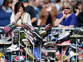 Running shoes hang from a makeshift memorial in Copley Square on Boylston Street in Boston, Wednesday, April 24, 2013. Traffic was allowed to flow all the way down Boylston Street on Wednesday morning for the first time since two explosions killed three people and injured many on April 15. (AP Photo/Michael Dwyer)